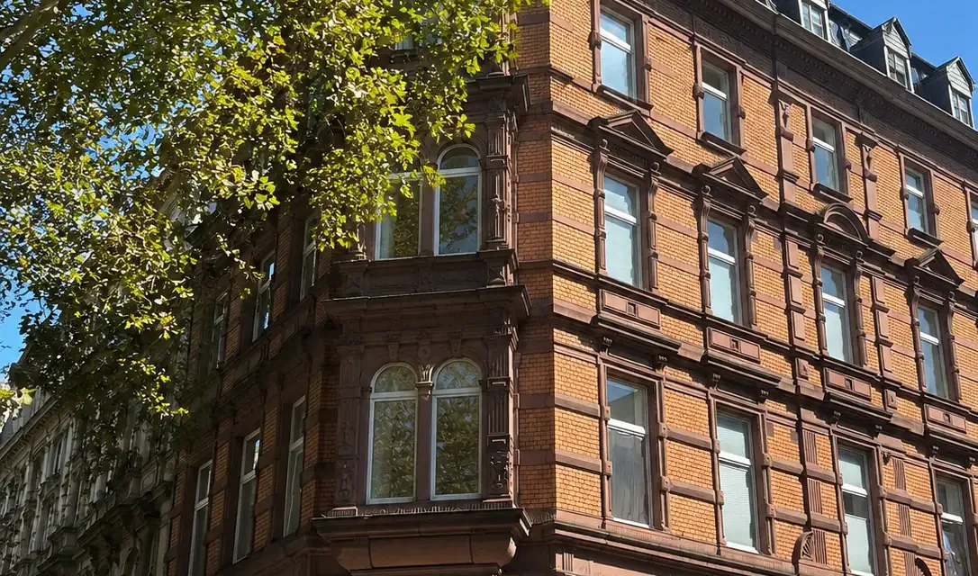 Die Gebäudeecke Hohenzollernring 28 / Ehrenstraße in Köln: Backsteinfassade mit Erker und Rundbogenfenstern