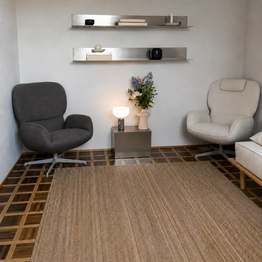Zwei Sessel in der Praxis in Köln, dazwischen ein Beistelltisch mit Lampe und Blumen